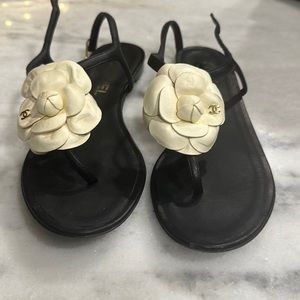 Chanel black leather thong sandals with ivory Chanel flower.